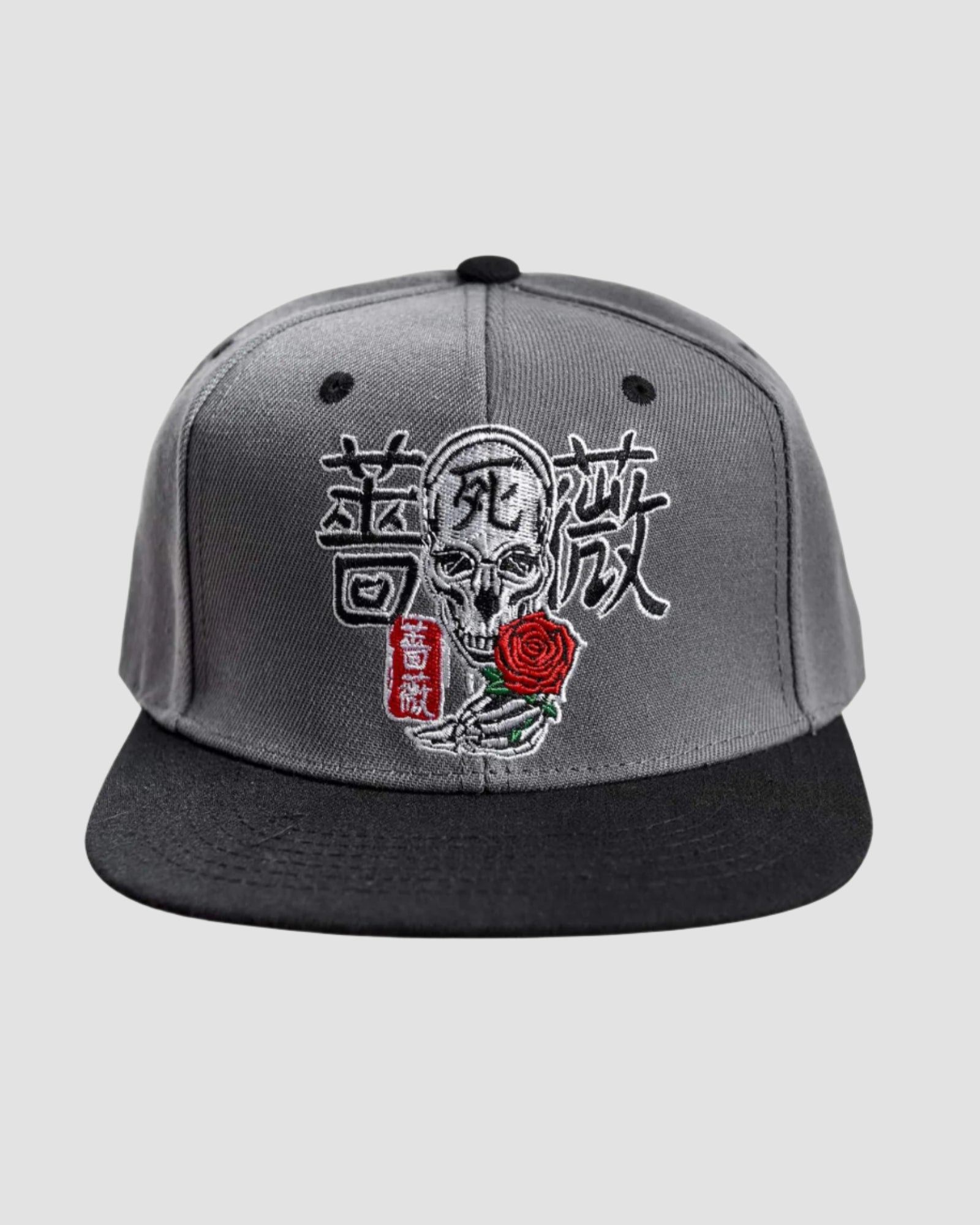 Front view of the Men’s Kanji Death Snapback by Ring of Fire Clothing in Black, Grey, White, and Red colors, showcasing the unique design of Japanese characters surrounding a skull with a rose.