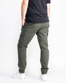 Person wearing a black t-shirt and green cargo pants on a white background