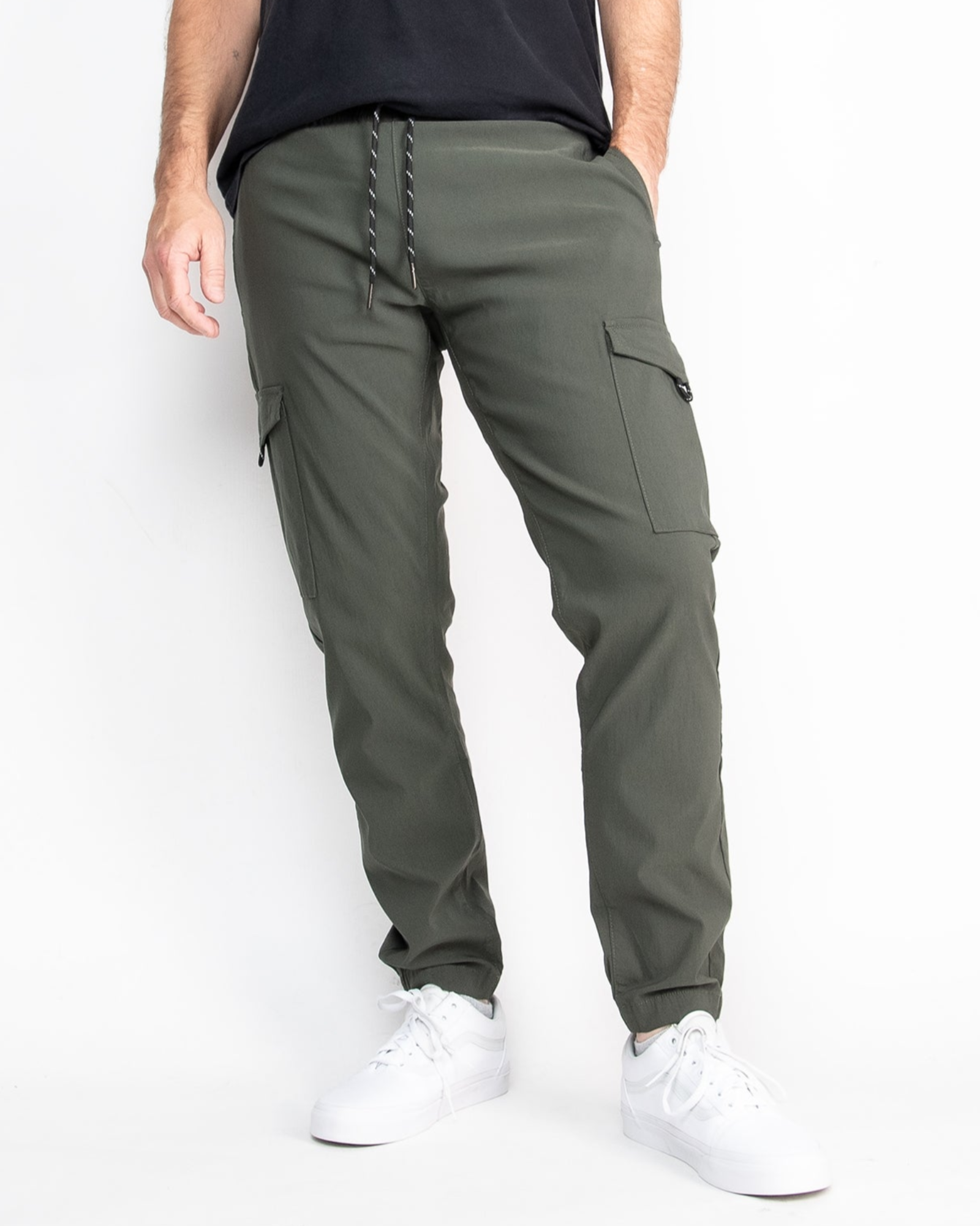 Person wearing olive green cargo pants with a plain background