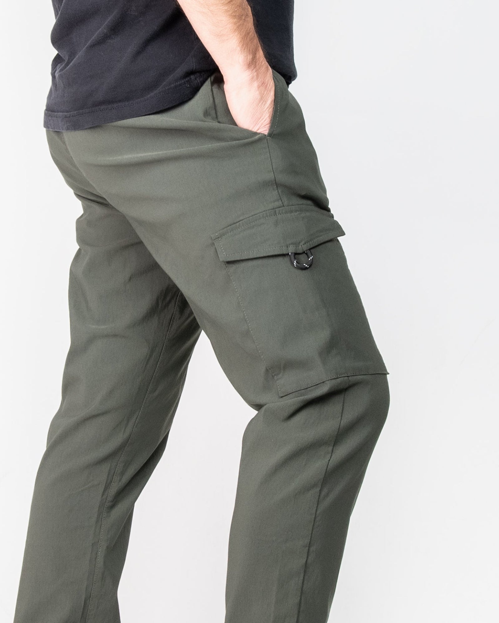 Green cargo pants worn by a person on a white background