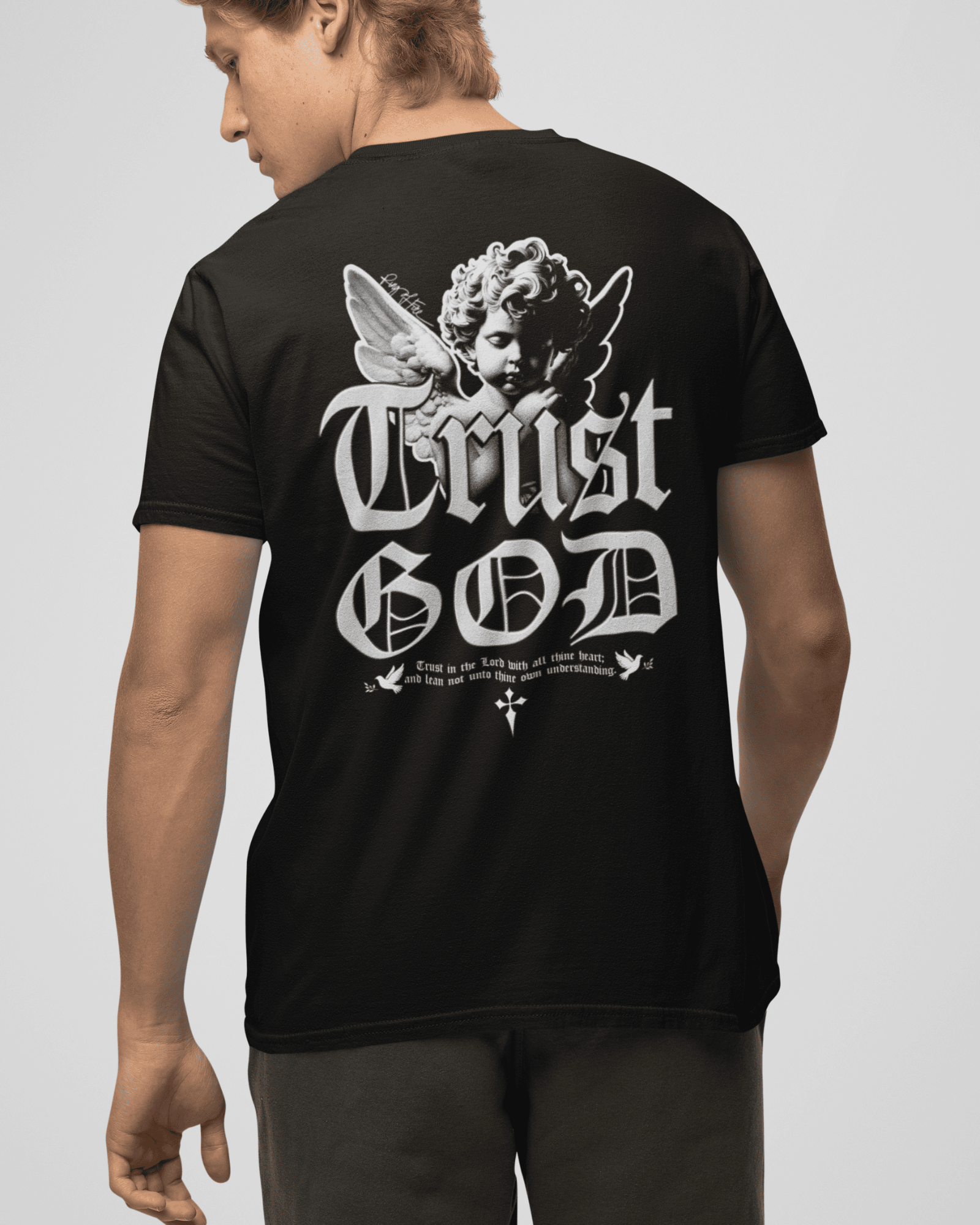 Person wearing a black t-shirt with 'Trust God' design on the back