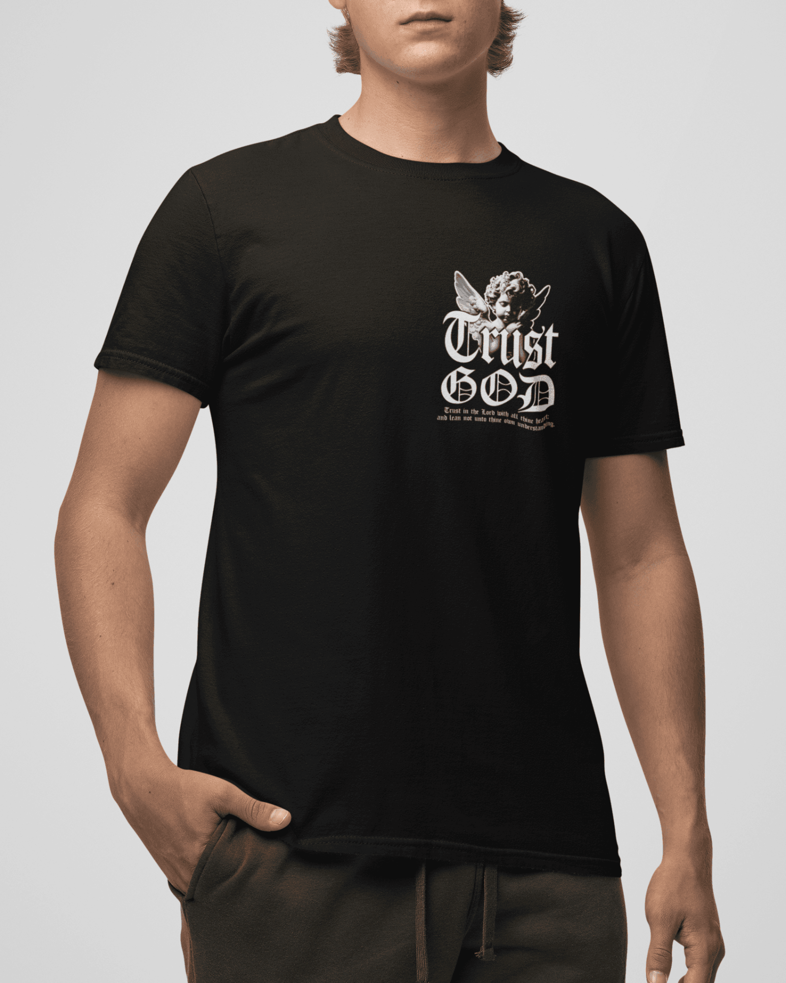 Person wearing a black t-shirt with 'Trust God' text on a plain background