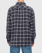 Person wearing a black and white plaid shirt on a light gray background