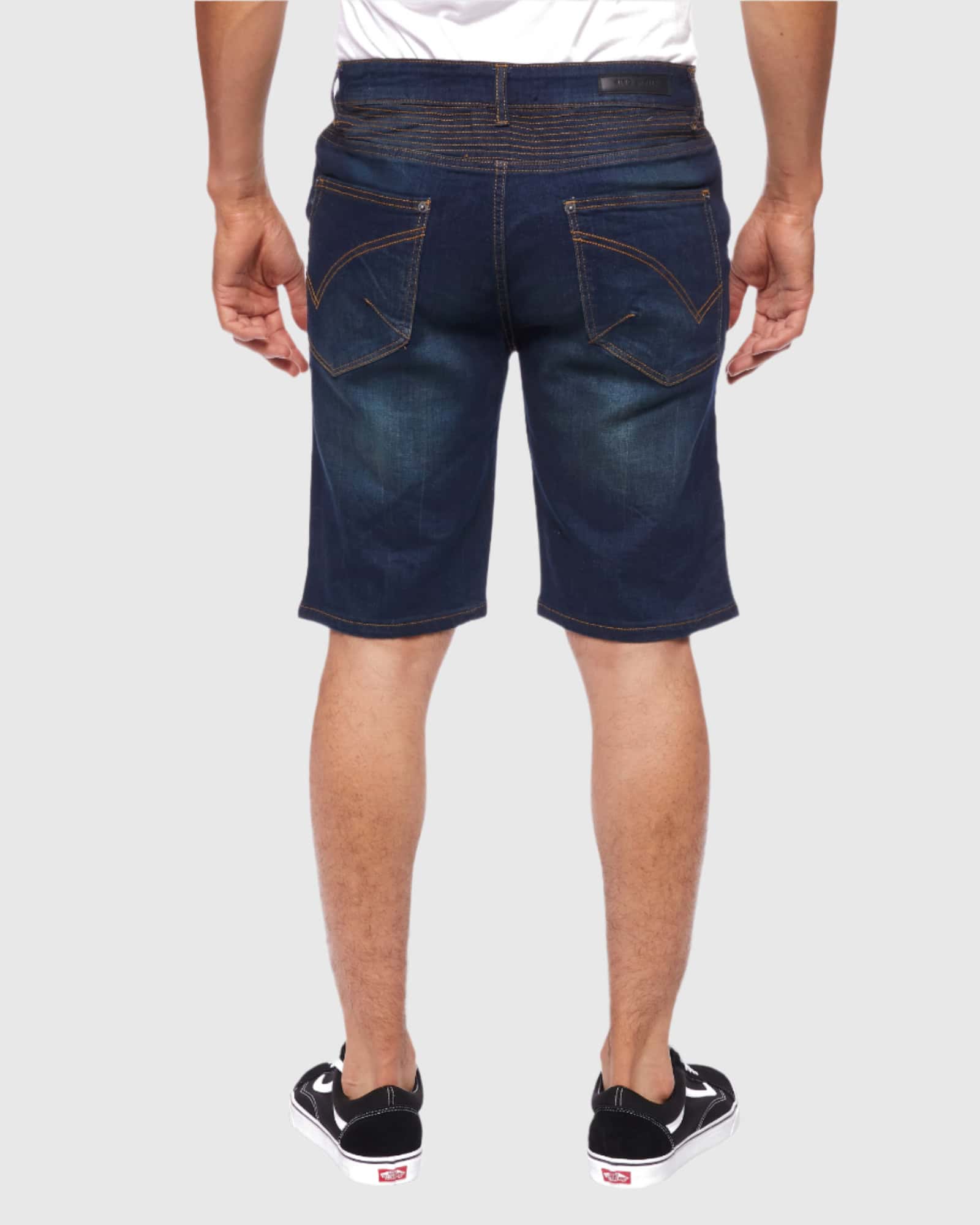 Back view of a model wearing the Men’s Brad Moto Denim Shorts, featuring two back pockets and a clear view of the loose-straight fit