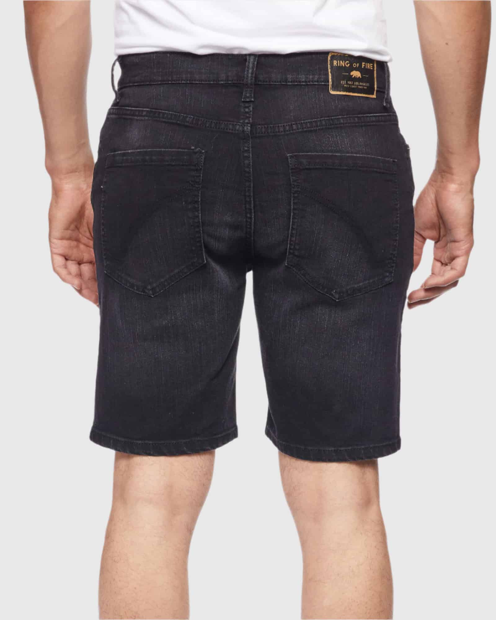 Back view of model in Carbon Men’s Ripper Denim Shorts from Ring of Fire