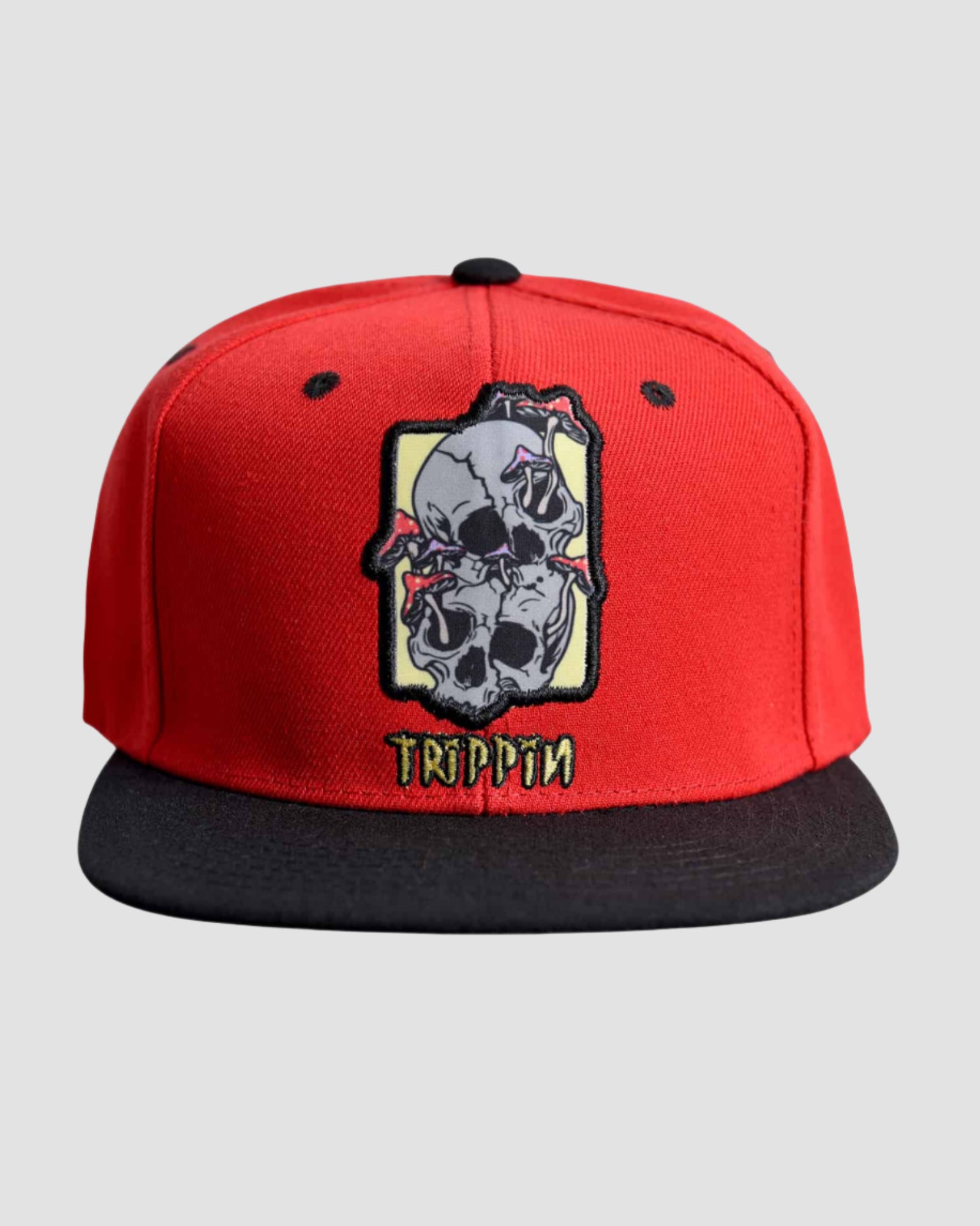 Front view of the ‘Men’s Trippin Snapback’ by Ring of Fire Clothing in Red Black Grey color, showcasing the unique dual skull design with mushrooms sprouting from the eye sockets, one size fits all.