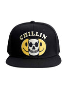 Front view of the ‘Men’s Chillin Snapback’ by Ring of Fire Clothing in Black, White, and Yellow color, showcasing the unique split happy face and skull design with ‘chillin’ text.