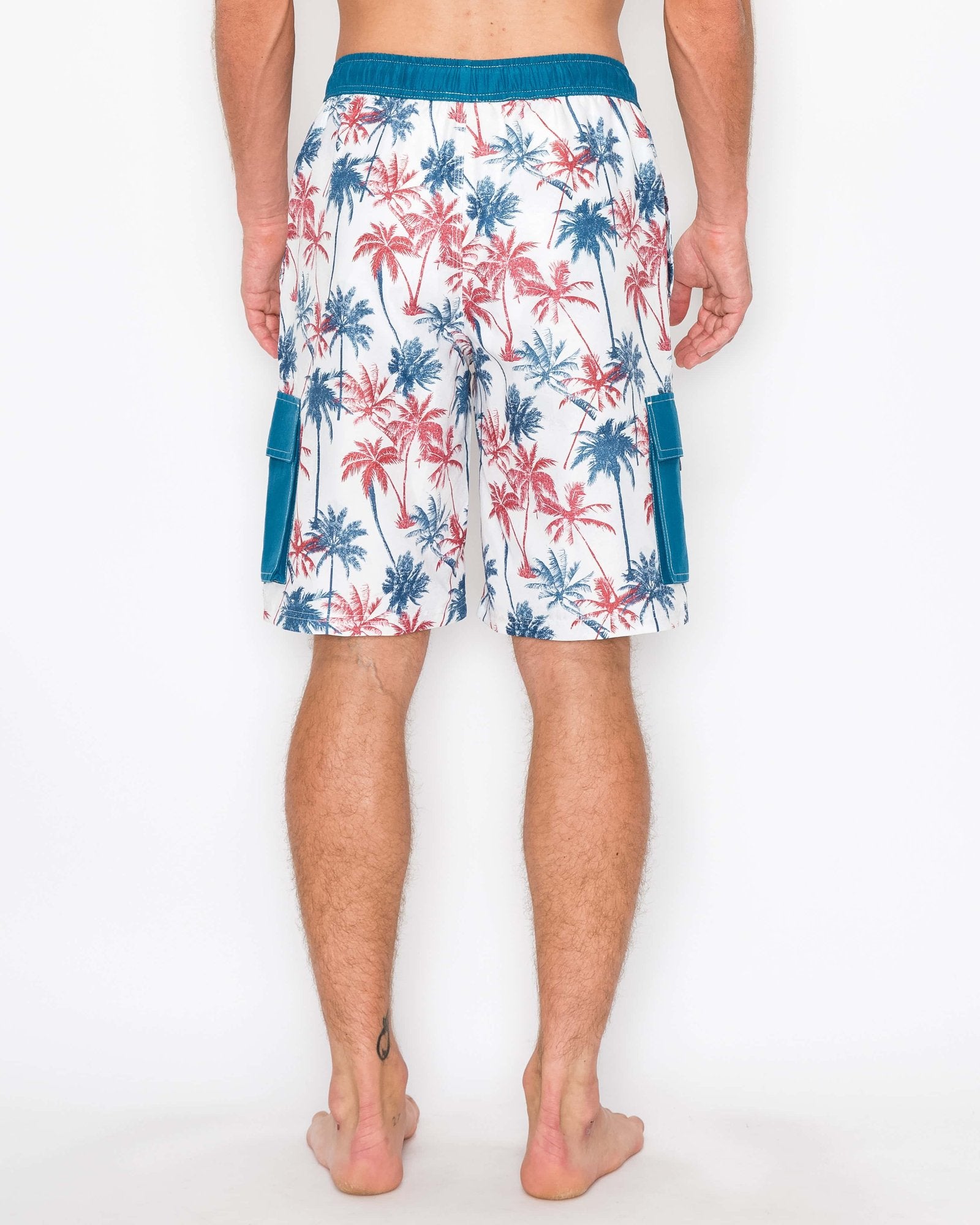 Back view of model wearing men’s boardshorts, showcasing the palm tree print and below-the-knee length.