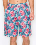 Close-up of Men’s Paradise Bloom Cargo Boardshorts front details, showcasing pink tropical flowers on a blue background with elastic waistband and drawstring closure.