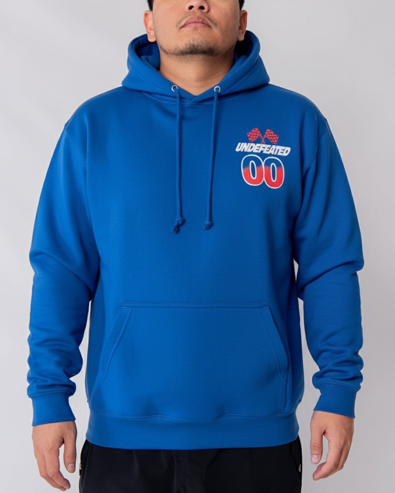 Person wearing a blue hoodie with 'Undefeated' logo on a gray background