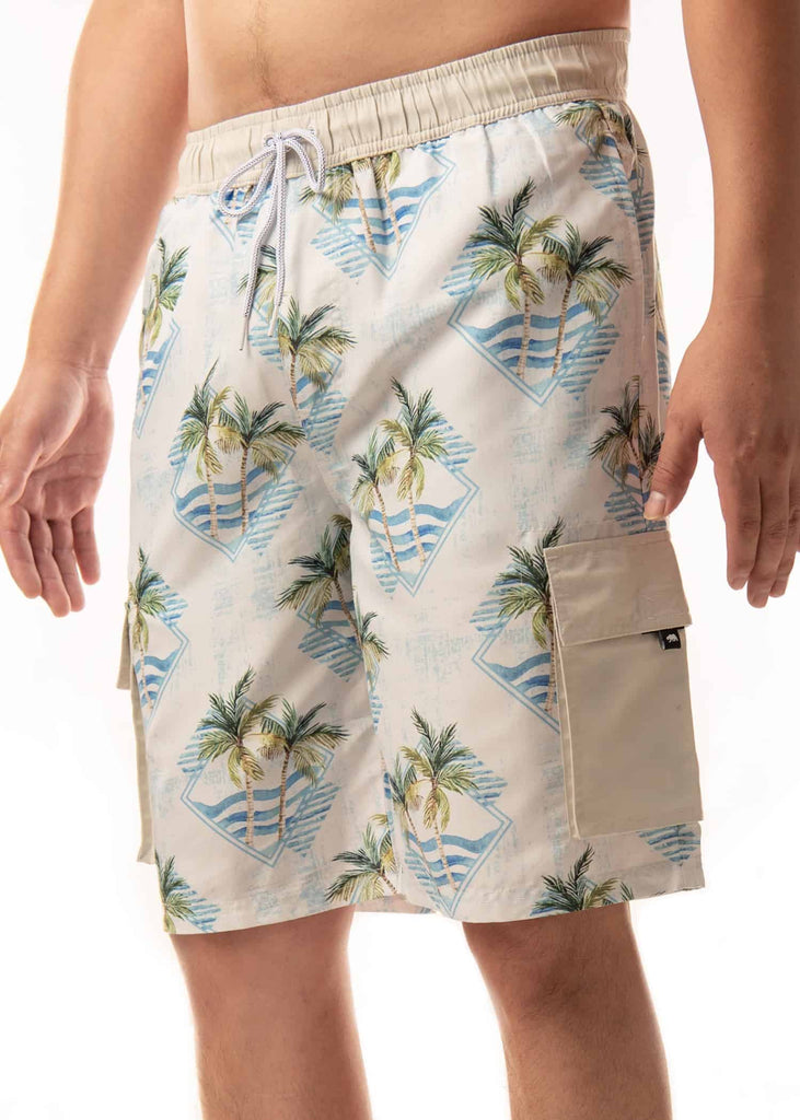 Angled view of a model wearing the Men’s Palm Geo Board Shorts, capturing the diamond blue background with waves