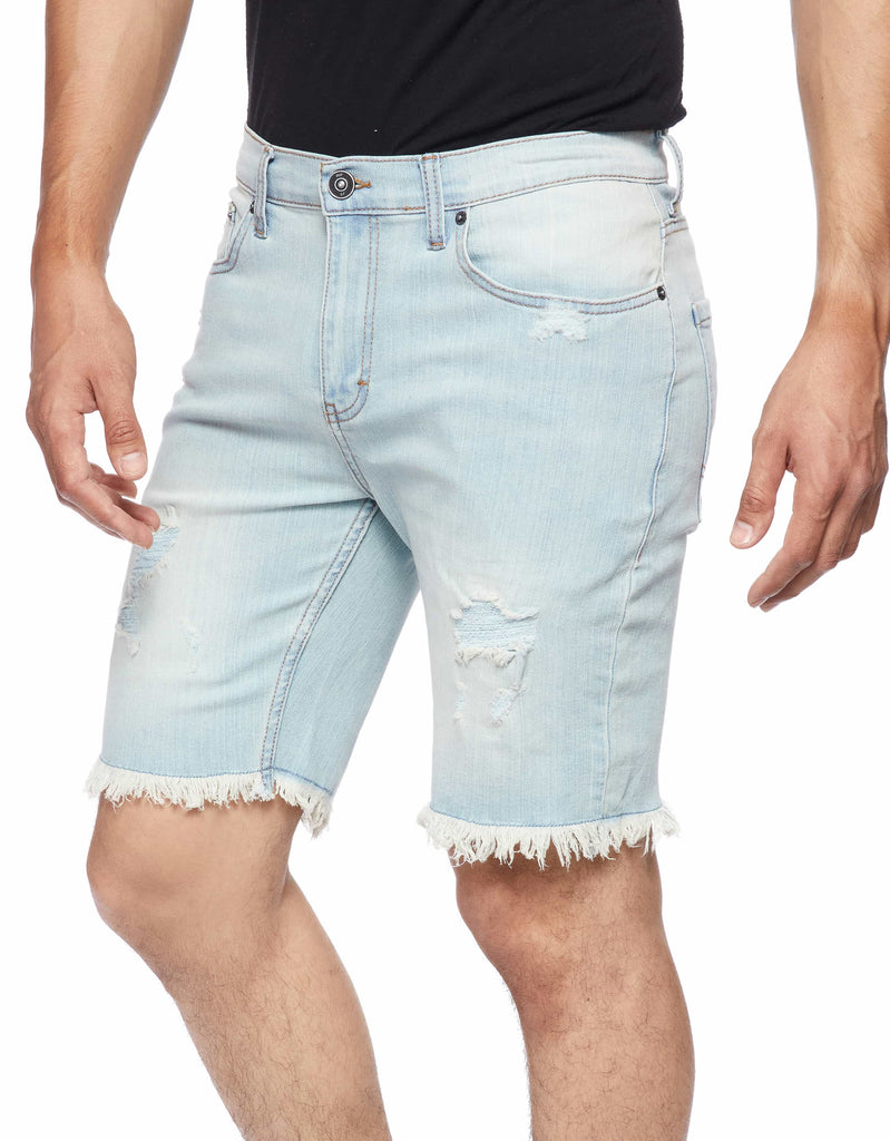 Side angle shot of a model wearing the Blue Bleached Men’s Raw Edge Ripper Denim Shorts, highlighting the relaxed fit and style